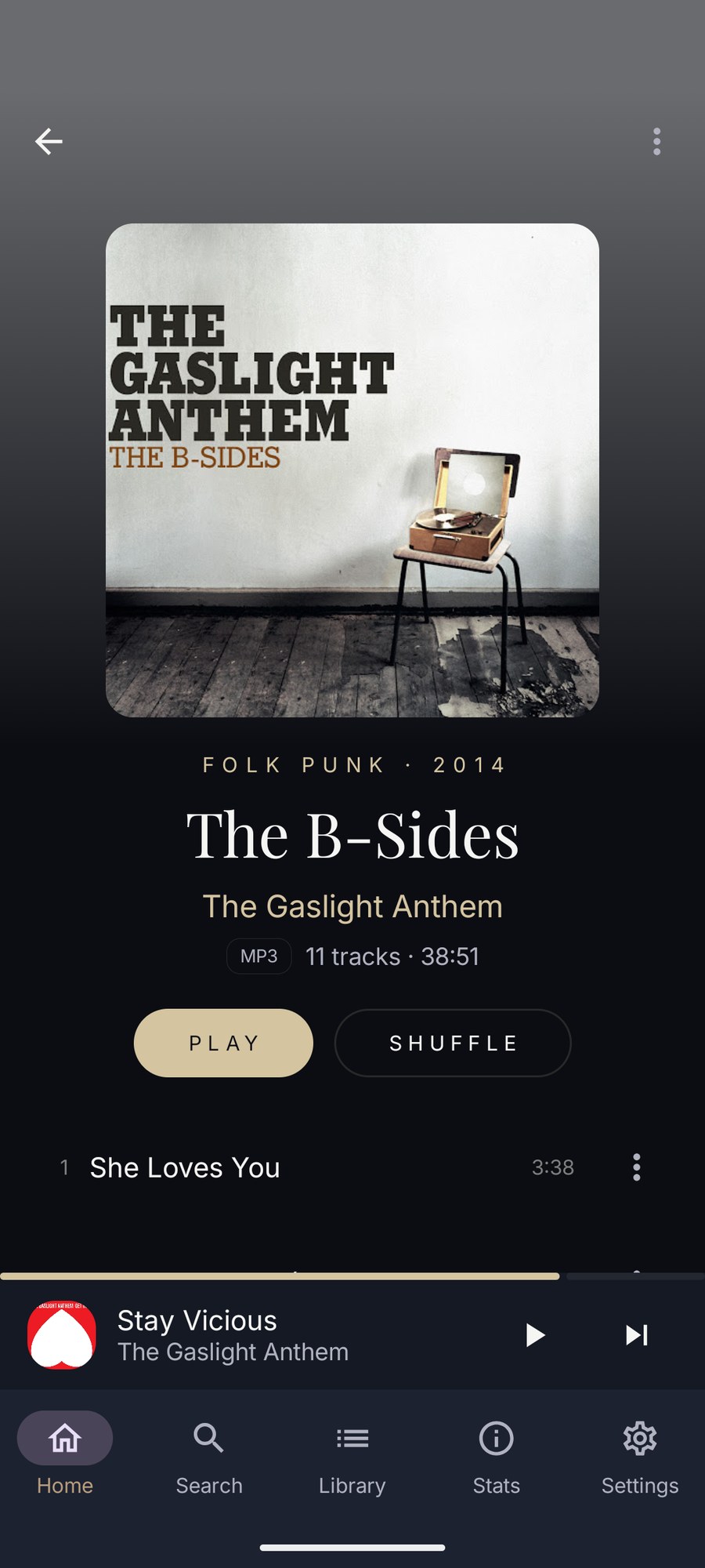 An album open on Android: artwork, genre and year, title and artist, the format and track count, Play and Shuffle buttons, and the first track.